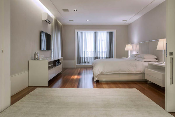 No quarto projetado por Diego Revollo, o piso de madeira recebeu um tapete cru