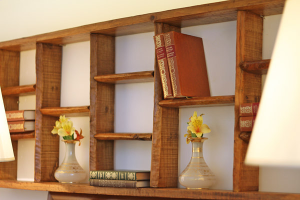 O antigo armário de tijolos hoje acomoda livros na parede